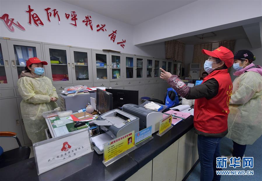 武汉市永清街道沈阳社区干部（右二）在社区办公室为同事分配工作任务（2月12日摄）。 新华社记者 李贺 摄
