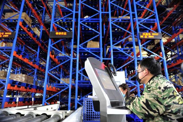 在江西一家工厂的生产线，操作员通过智能选料设备准备零部件。（李悭摄）