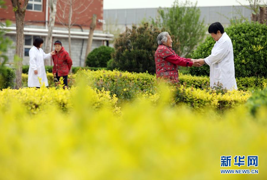 　在河北省衡水市桃城区一家养老康复医疗中心，护工在陪老人散步（2019年5月5日摄）。新华社记者 牟宇 摄