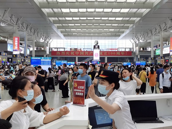 图说：上海虹桥站12306服务站工作人员为旅客提供咨询服务  王程伟 摄