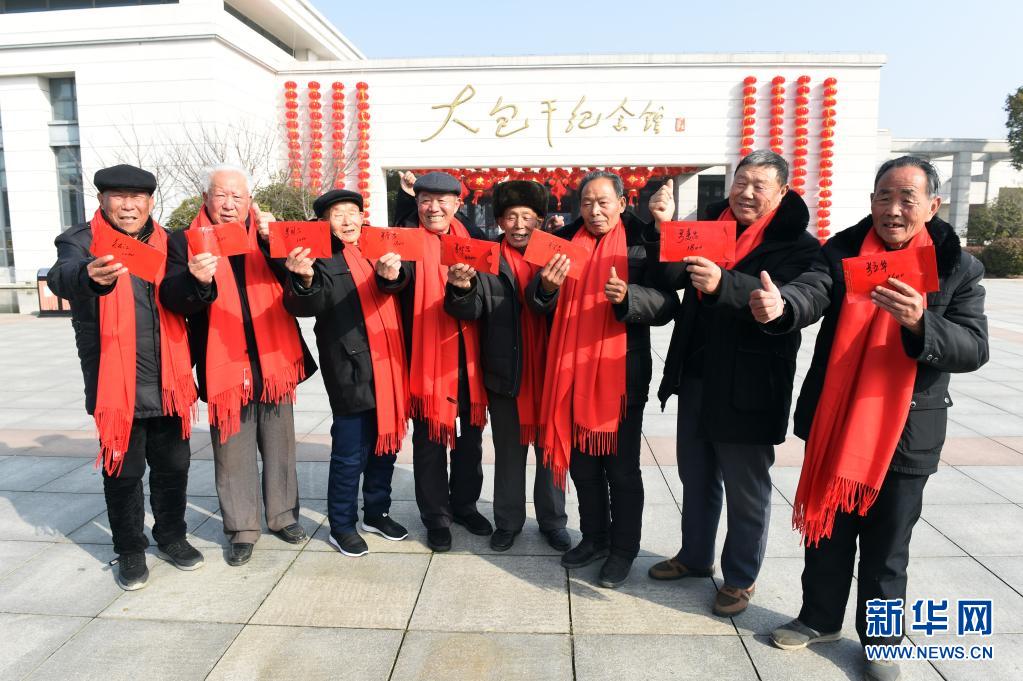 2月3日，在安徽省滁州市凤阳县小岗村，8位“大包干”带头人在大包干纪念馆前展示自家领取的集体经济收益股权分红。新华社记者 周牧 摄