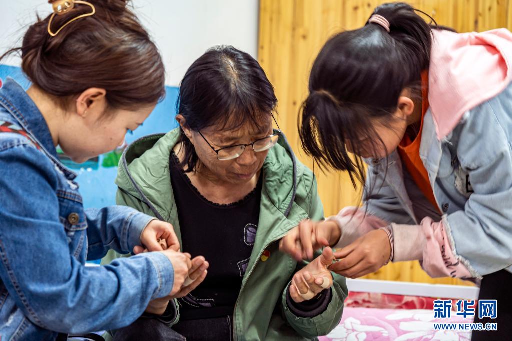 每天回到福利院，孩子们都会帮张桂梅撕掉贴了一天的止痛胶带（3月23日摄）。新华社记者 江文耀 摄