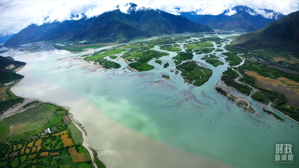 △雅鲁藏布江（左侧）与尼洋河（右侧）在此地交汇，两江合流呈现一清一浊、泾渭分明的景观。（总台记者康晓宇拍摄）