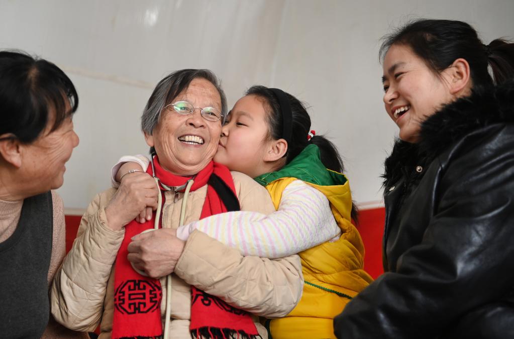路生梅（左二）在佳县佳州街道凌云社区义诊时，小患者亲密拥抱她。新华社记者陶明 摄