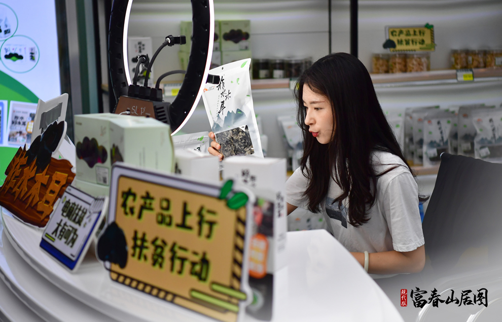 在陕西柞水县小岭镇金米村木耳展销中心内，电商主播何锦漪通过直播售卖柞水木耳（2020年7月21日摄）。