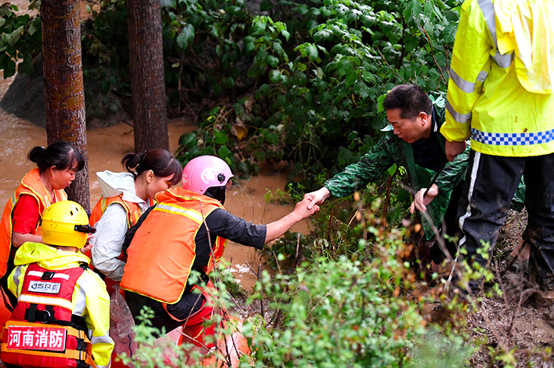 2021年7月20日，河南省登封市唐庄镇龙头村附近突发山洪，消防救援人员在转移被困村民。