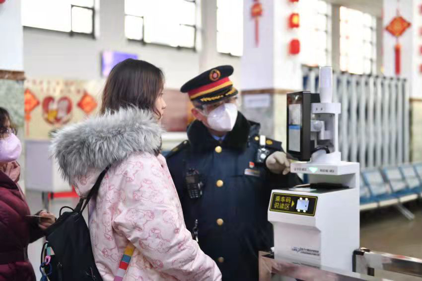 测温机器人对进站乘车的旅客测量体温，并提醒旅客佩戴口罩