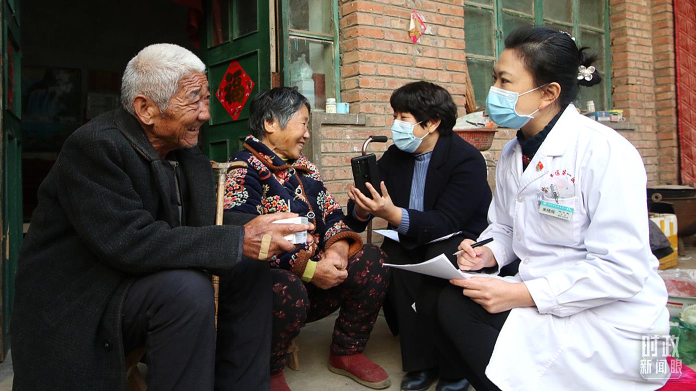 △2021年12月，河北邯郸，工作人员为村民讲解医保政策。（图/视觉中国）