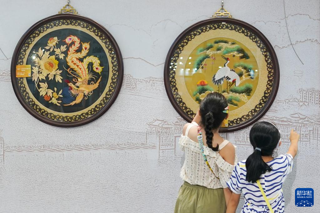 8月18日，观众在第二届中国工艺美术博览会参观织绣类艺术展品。