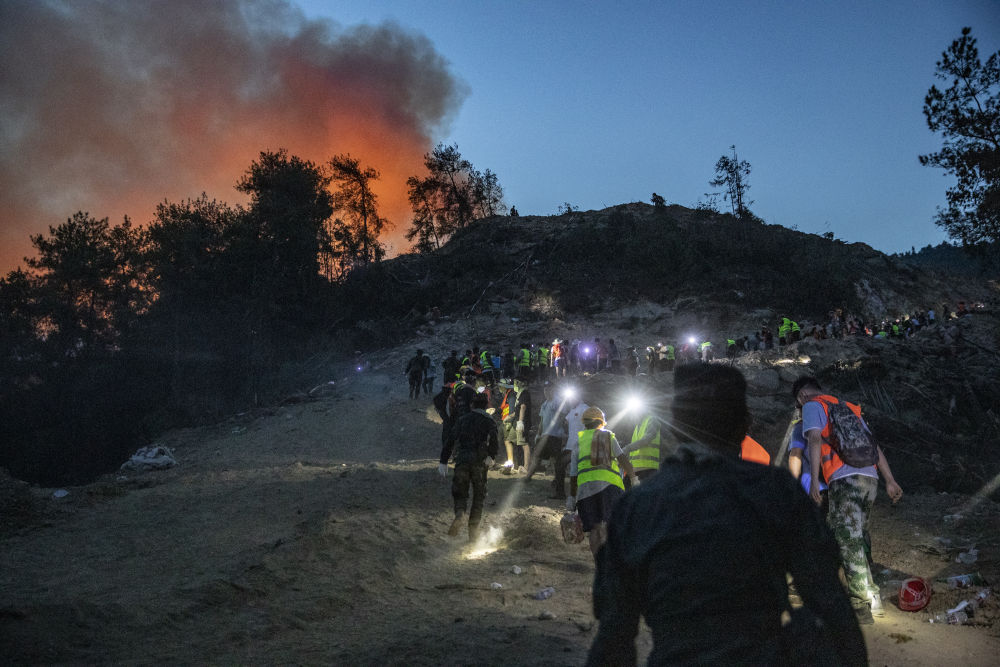 8月25日，在重庆市北碚区缙云山，救援人员逆行前往火场灭火。