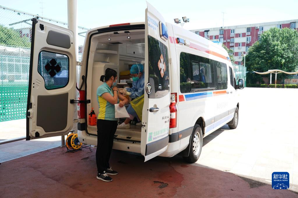 　　2022年7月13日，在北京市海淀区北下关街道中国农业科学院社区新冠疫苗临时接种点，医护人员在流动疫苗接种车上为社区居民接种。