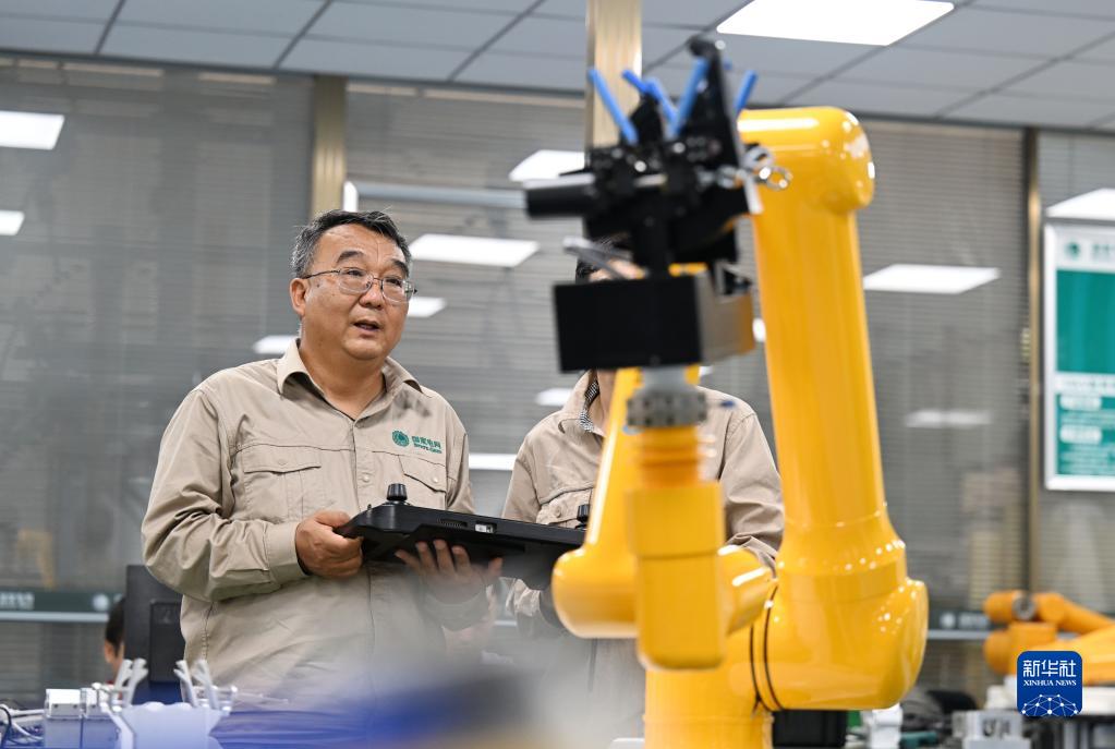 张黎明和同事在调试第四代配网带电作业机器人（2022年9月8日摄）。