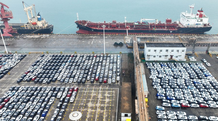 This aerial photo shows vehicles waiting to be exported at a port in Lianyungang, east China‘s Jiangsu Province, Jan. 13, 2023. (Photo by Geng Yuhe/Xinhua)