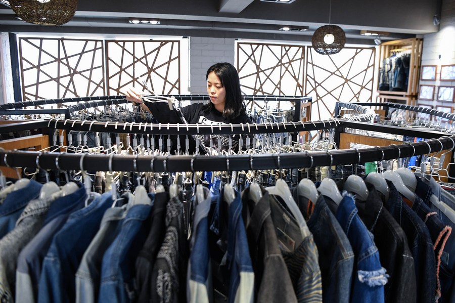 A staff member sorts clothes to be displayed online for the 132nd session of the China Import and Export Fair, also known as the Canton Fair, at Guangdong Textiles Import & Export Co., Ltd. in Guangzhou, south China‘s Guangdong Province, Oct. 14, 2022. (Xinhua/Deng Hua)
