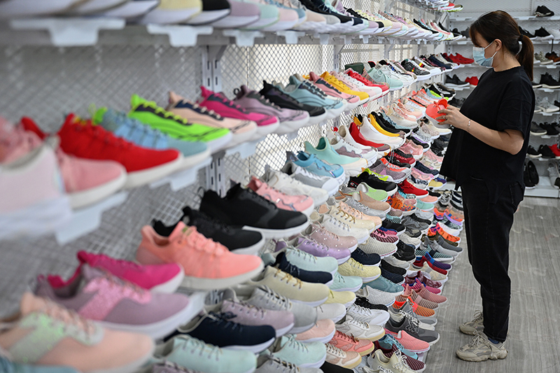 2022年5月16日，在福建省晋江国际鞋纺城，一家鞋材企业的销售人员在整理货架。