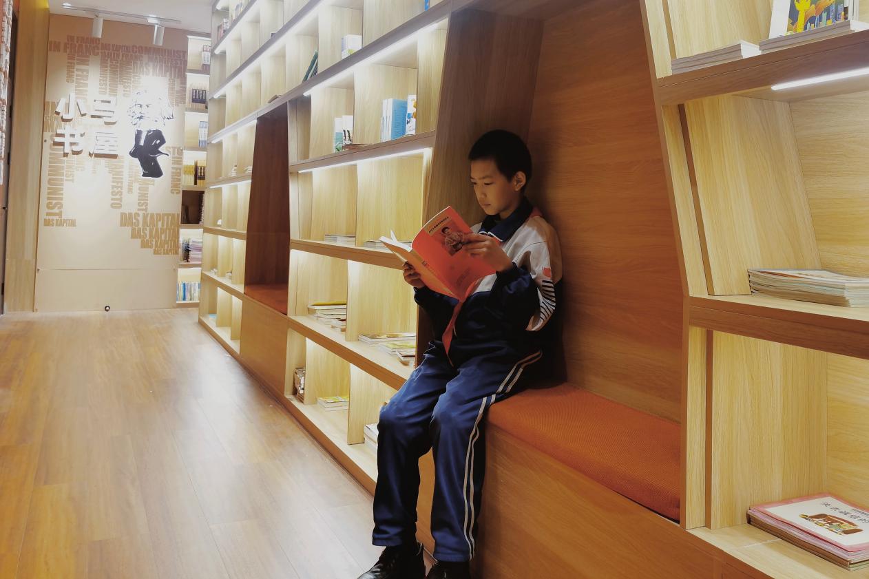Reading under the bookshelf makes Gao Hongjun feel particularly comfortable. (Photo by wanglili)