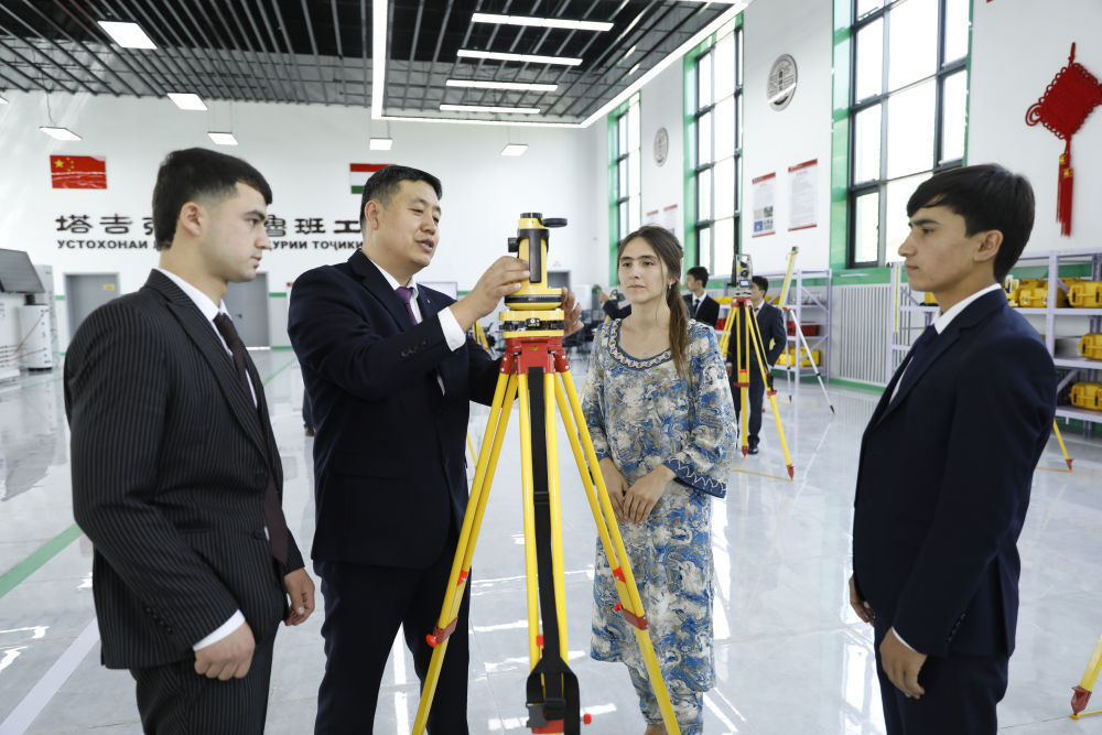 在塔吉克斯坦首都杜尚别的鲁班工坊内，来自天津城市建设管理职业技术学院的老师吴正鹏（左二）向学生讲解测绘仪器使用方法（2023年4月12日摄）。新华社发（奥斯帕诺夫摄）