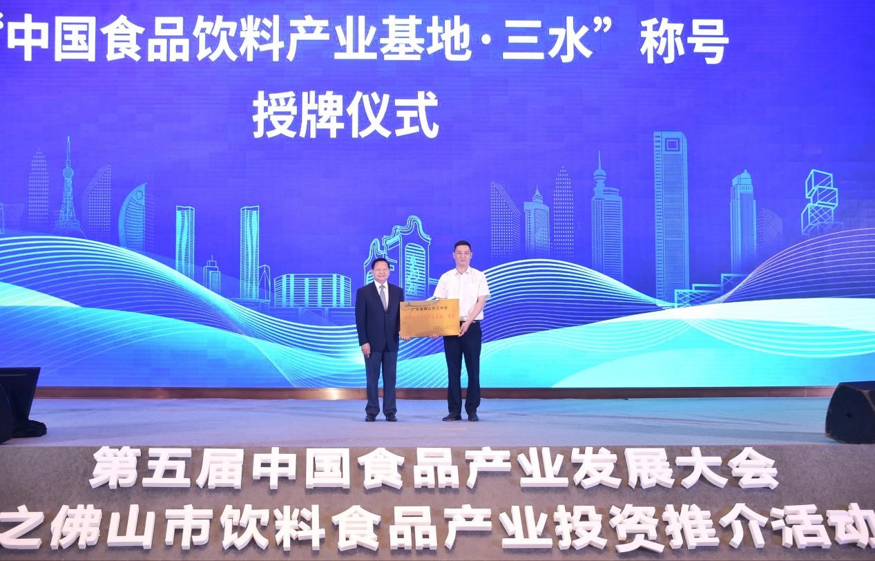 三水区区长黄海(右)从中国轻工业联合会会长张崇和手中接过“中国食品饮料产业基地·三水”牌匾