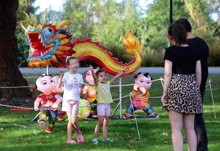 Children pose for photos in front of a dragon-shaped installation to welcome the Chinese Lunar New Year at Hagley Park in Christchurch, New Zealand, Feb. 9, 2024. TO GO WITH "Feature: New Zealanders greet Year of Dragon" (Photo by Meng Tao/Xinhua)
