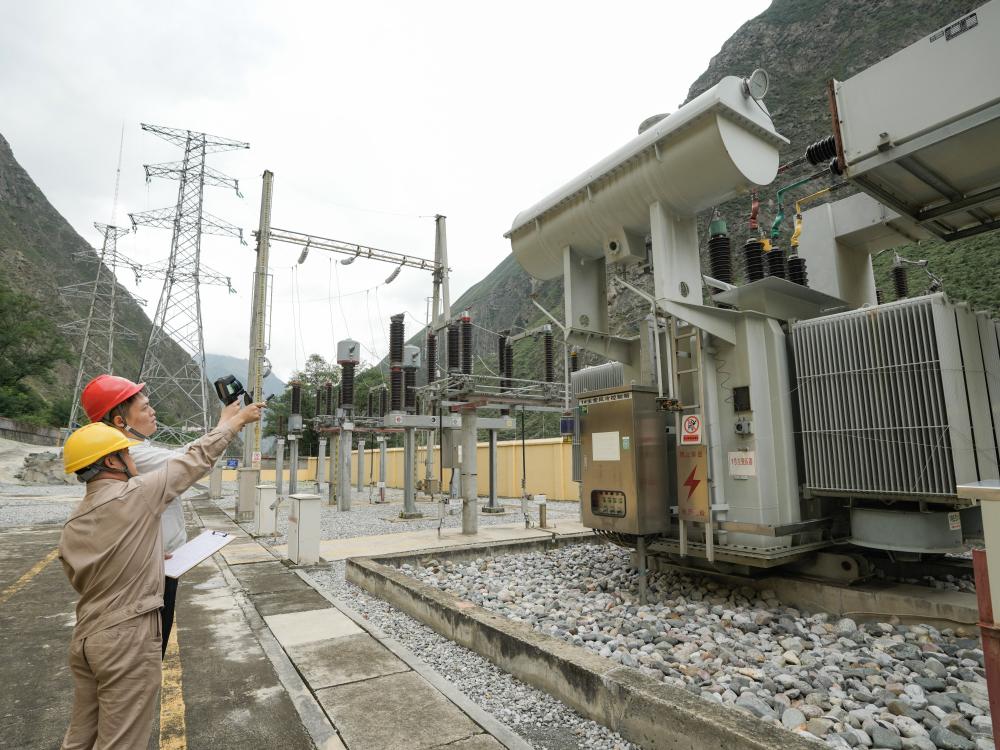 9月17日，在四川省汶川县灞州镇下庄水电站，国网四川岷江供电有限责任公司电力可靠性管理员朱鹏宇（后）和同事对升压站变压器进行例行测温。 新华社记者 王曦 摄