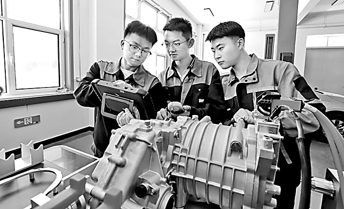 甘肃省张掖市高台职业中等专业学校，同学们在进行新能源汽车变速器检查操作实训演练。王将摄/光明图片
