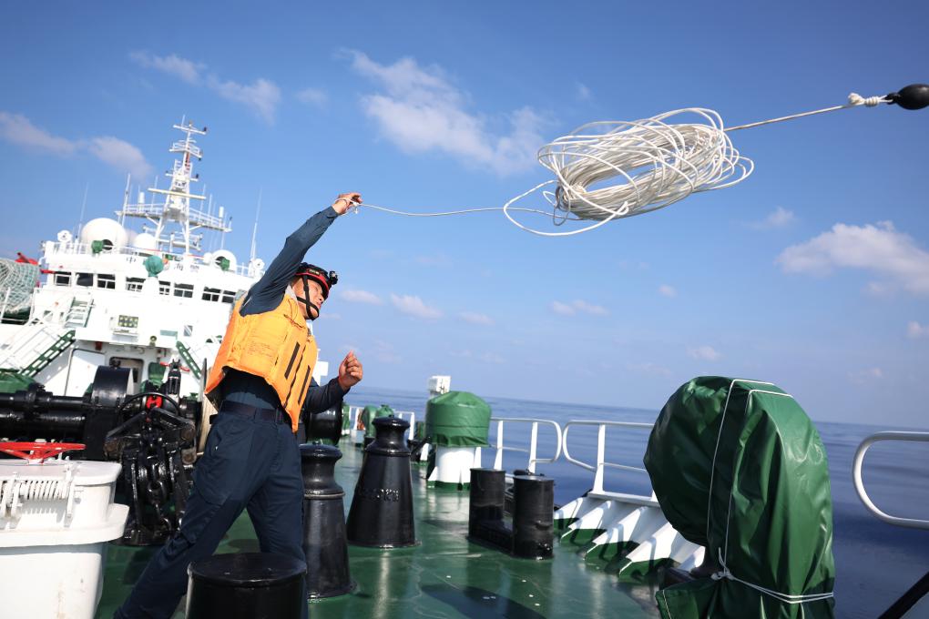5月19日，海警执法员王鑫在川山舰甲板上进行海上抛缆绳训练。新华社记者 陈斌 摄