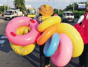 一商贩在马路上卖泳具. 本栏图片均由古月 摄